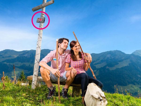 junges Paar auf berggipfel genießt Audio Info - Sprachassistenten im Tourismus