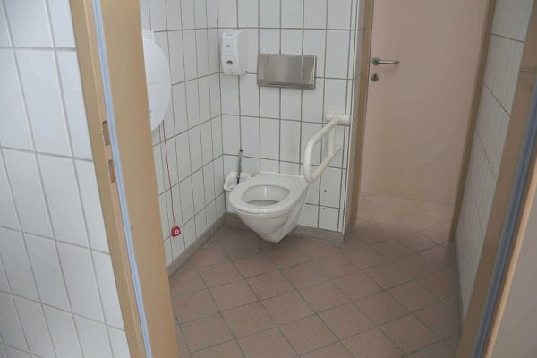 Hässliches WC, das für Rollstuhlnutzer nicht benutzbar ist.