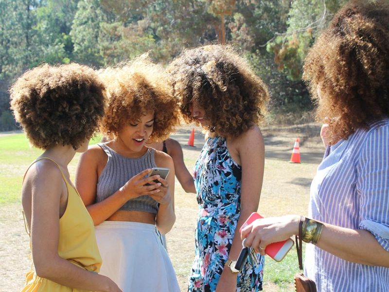 Tourismus Apps - Gruppe junger Mädchen mit Smartphones im Freien