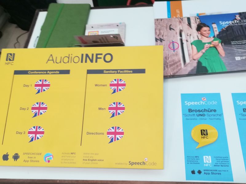 Gelbe Tafel mit Sprechblasen zu Einlesen der Agenda der Konferenz zur Barrierefreiheit im Audio Format