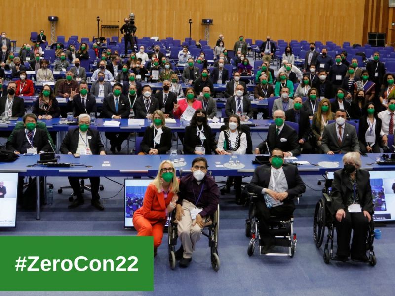 Participants of the ZeroCon22 sitting at tables in the main conference room, facing the camera